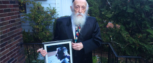 Twerski, wearing a Peanuts tie, holds a photograph of Schulz